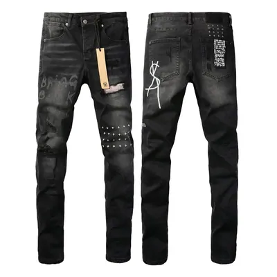 Two pairs of black ripped jeans laid side by side, one of them still carrying its paper tag.